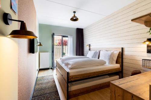 ein Schlafzimmer mit einem Bett in der Ecke eines Zimmers in der Unterkunft Hotel De Kroon in Kaatsheuvel
