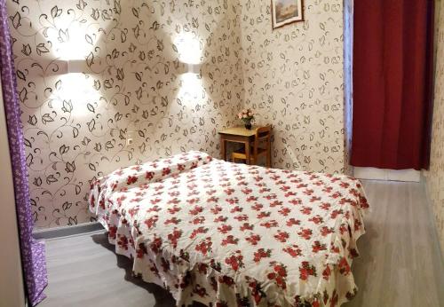 a bedroom with a bed with a red and white blanket at Saint Francois Xavier in Lourdes