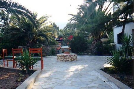 a patio with two benches and a fire place at Villa Maria Vekri in Koufonisia