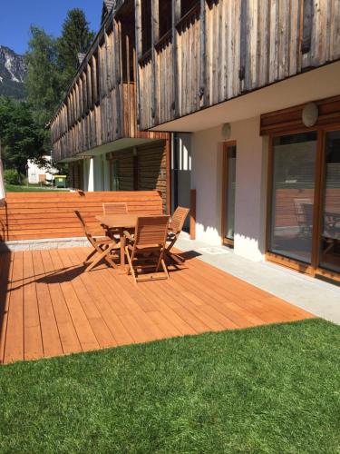 a wooden deck with two chairs and a table at Apartma Pika in Mojstrana