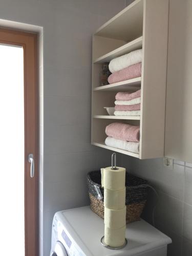 una lavandería con toallas en un armario blanco en Apartma Pika, en Mojstrana