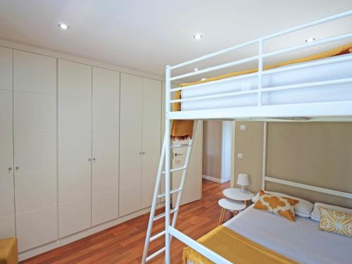 a bedroom with a bunk bed and white cabinets at Del parque flats casa rincón del sol in Rincón de la Victoria