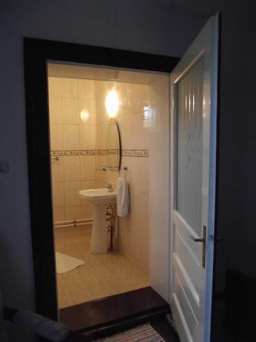 a bathroom with a sink and a toilet with a mirror at Casa Bunicii - Bran Sohodol in Sohodol