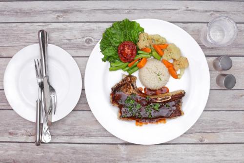 a plate of food with meat and vegetables on a table at Hotel Access Nepal in Kathmandu