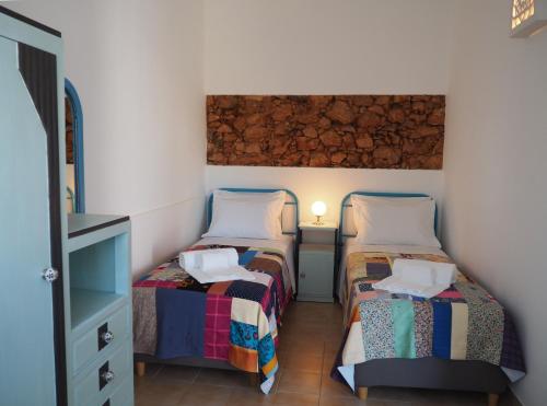 a twin bedroom with two beds and a dresser at Quinta do Maranhão in Lagos