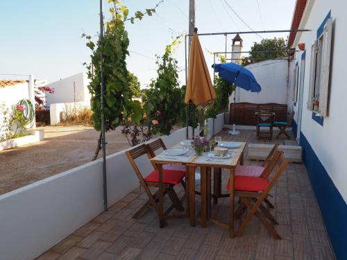 a table and chairs on a balcony with an umbrella at Quinta do Maranhão in Lagos