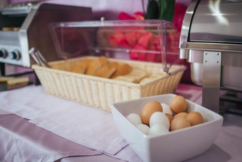 a bowl of eggs and a basket of bread at Le Vele di Balestrate in Balestrate