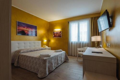 a hotel room with a bed and a television at Le Vele di Balestrate in Balestrate