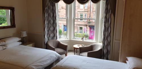 um quarto de hotel com duas camas e uma janela em Highfield Guest House em Edimburgo