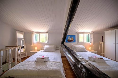 two beds in a room with white walls and windows at Corfu Villa Linea in Línia