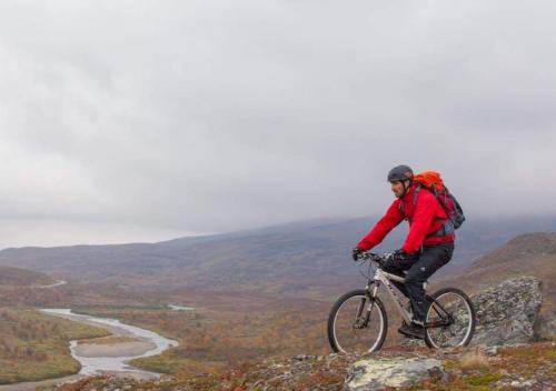 a man riding a bike on top of a mountain at Hotell Klimpfjäll in Klimpfjäll