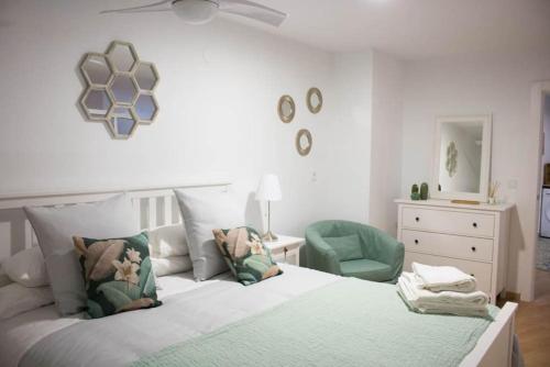 a bedroom with a bed and a green chair at Apartamento Reyes Catolicos in Almería