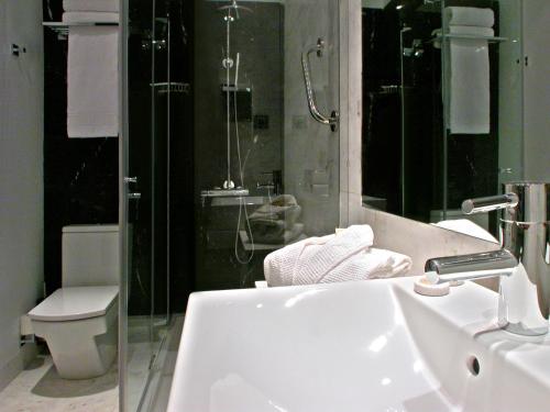 a bathroom with a sink and a toilet and a shower at Grupotel Gran Via 678 in Barcelona