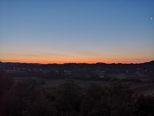 a sunset over a field with trees in the foreground at Apartment Viksa with Jacuzzi in Zagreb