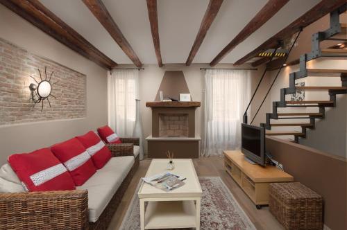 een woonkamer met een bank, een tv en een trap bij Angelo d'Oro Holiday Home Silva in Rovinj