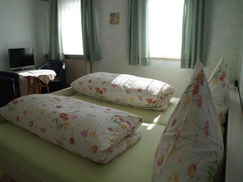 2 almohadas sentadas en una cama en una habitación en Gästehaus Erath, en Lindau-Bodolz