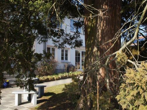 un banco sentado frente a una casa blanca en Gästehaus Erath, en Lindau-Bodolz