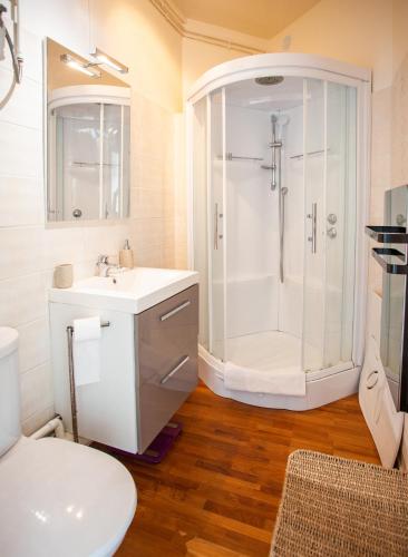 une salle de bain blanche avec une douche et un lavabo dans l'établissement Très bel appartement idéal couple et famille, à Villers-sur-Mer