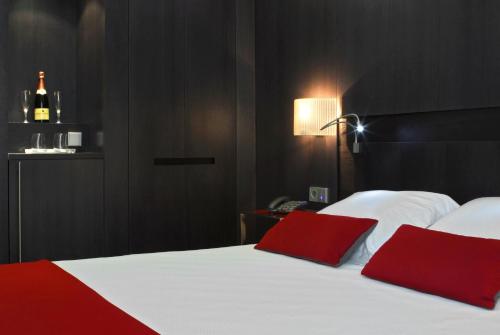 a bedroom with a bed with two red pillows at Grupotel Gran Via 678 in Barcelona