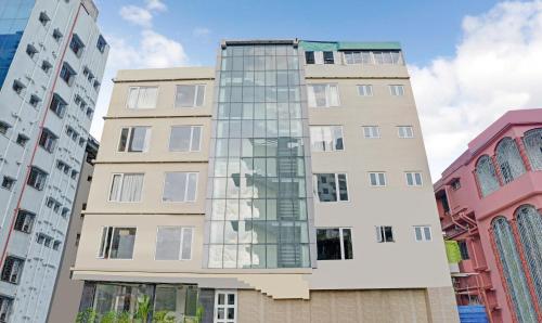 a tall building with glass windows in a city at Treebo Tryst The Crystal in Kolkata