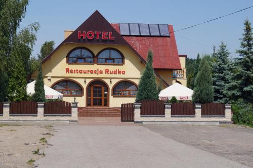 a hotel with a sign on the front of it at Hotel-Restauracja-Bar Rudka in Ostrowiec Świętokrzyski