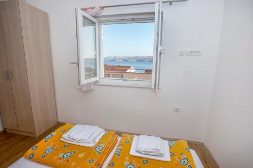 a bed in a room with a window at Apartments Villa Dina in Karlobag