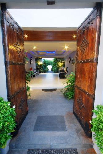 an open door into a room with a hallway with plants at Villa Labaron in Koh Samui 