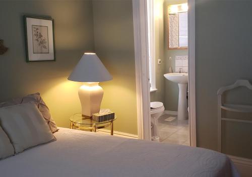 a bedroom with a bed with a lamp and a bathroom at Harrington House Picton in Picton