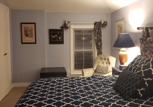 a bedroom with a bed and a chair and a window at Harrington House Picton in Picton