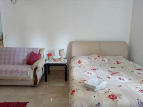 a bedroom with a bed and a couch and a table at Apartman Strahinja in Tivat