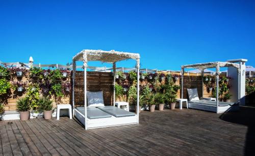 a patio with two beds on a roof at Capsis Astoria Heraklion in Heraklio Town