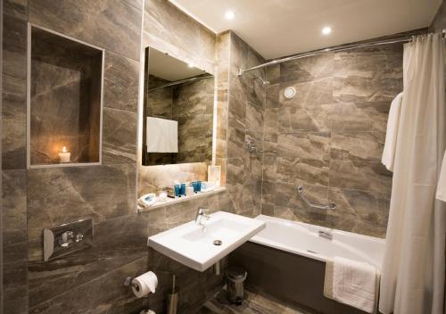 
a bathroom with a sink, toilet and bathtub at Midleton Park Hotel in Midleton
