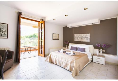 a bedroom with a large bed and a balcony at Casa del Sole in Cinisi