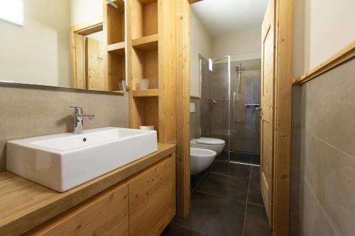 a bathroom with a white sink and a toilet at HOTEL AD Residence in Bormio