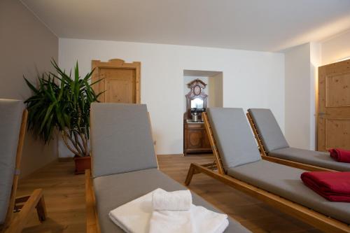 a living room with two chairs and a clock at HOTEL AD Residence in Bormio