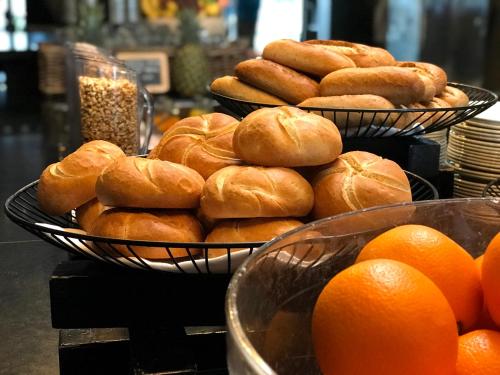 two baskets filled with donuts and oranges on a counter at Fletcher Hotel-Restaurant Kasteel Erenstein in Kerkrade