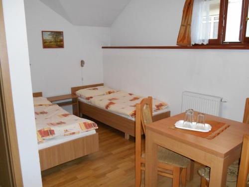 una piccola stanza con due letti e un tavolo di Penzión Pars a Žilina