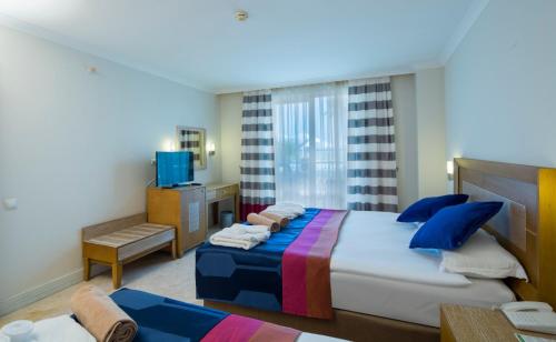 une chambre d'hôtel avec un lit et une télévision dans l'établissement Crystal Boutique Beach & Resort - Adult Only, à Belek