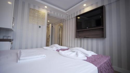 a bedroom with white towels on a bed with a television at Burj Al Istanbul in Istanbul