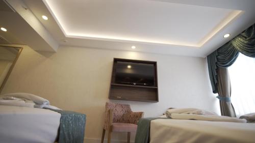 a room with two beds and a tv on the wall at Burj Al Istanbul in Istanbul