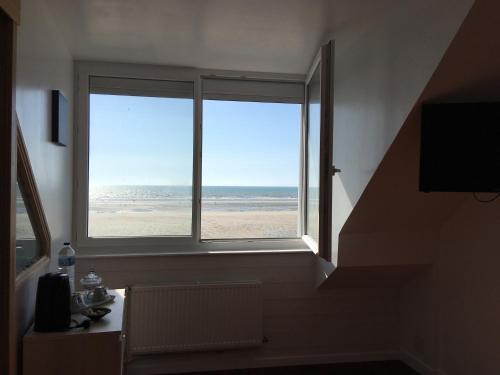 a bathroom with a window with a view of the beach at Les Chambres d'Hôtes de la Mer in Merlimont