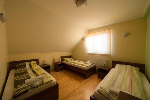 a small room with two beds and a window at Bíbic Vendégházak in Nagybajom