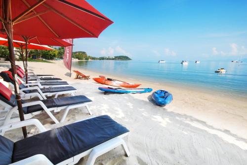 a group of chairs and umbrellas on a beach at Villa Labaron in Koh Samui 
