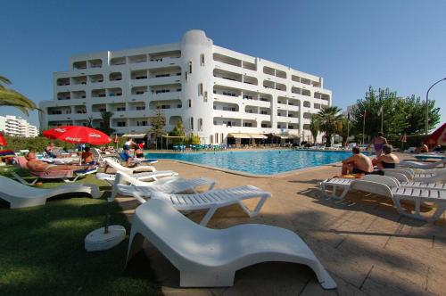 un grande edificio con piscina con persone che ci siedono intorno di Apartamentos Turisticos Silchoro ad Albufeira
