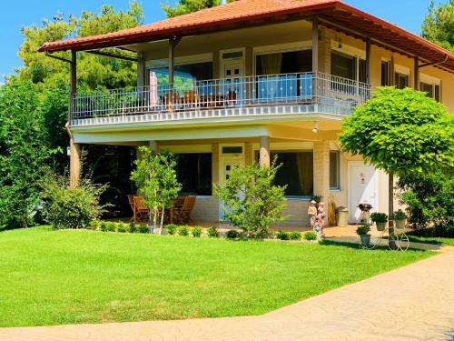 ネア・カリクラティアにあるKtima Anatoli Luxury Resort Residencesのバルコニーと庭付きの大きな家