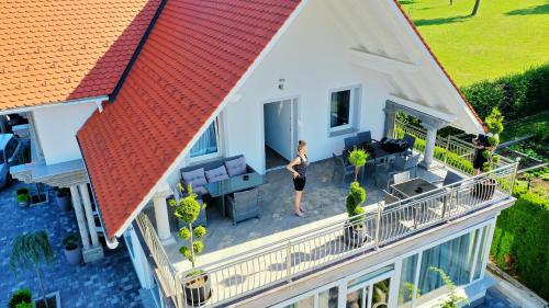 a woman standing on the balcony of a house at Vila Lemic Postojna in Postojna