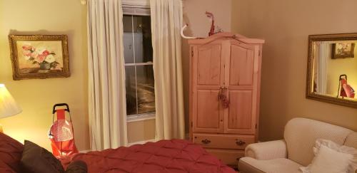 a bedroom with a bed and a cabinet and a window at Harrington House Picton in Picton