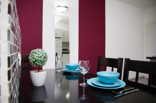 a dining room table with blue dishes and wine glasses at Apartments4you Maria in Bat Yam