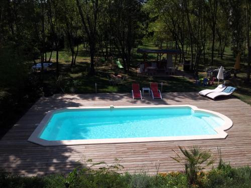 - une piscine avec deux chaises dans l'arrière-cour dans l'établissement La Comtadine, à Avignon