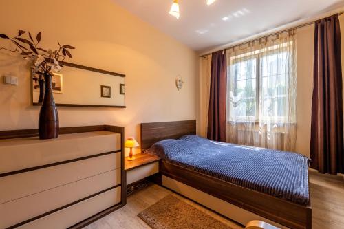 a bedroom with a bed and a window at Victus Apartamenty, Apartament Walor in Sopot